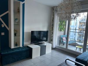 Il comprend un salon doté d'une télévision à écran plat et d'une fenêtre. dans l'établissement Le 13OR - Appartement plein centre parking et terrasse, à Marseille