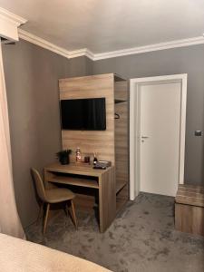 a bedroom with a desk with a television and a door at Hotel Cocó in Timişoara