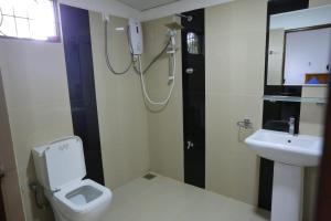 a bathroom with a shower and a toilet and a sink at Kumbuk Sewana Villa in Anuradhapura