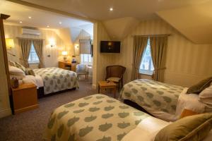 um quarto de hotel com duas camas e uma cadeira em Royal Oak Hotel em Betws-y-coed