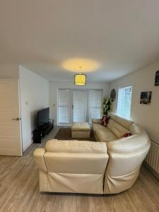 a living room with a white couch and a television at Home Away in Swanscombe