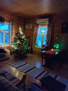 a living room with a christmas tree in a room at Granny´s House Kuusela in Portimo
