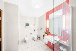 a white bathroom with a toilet and a sink at Prostorný dvoupokojový apartmán 52m2 in Plzeň +14 photos