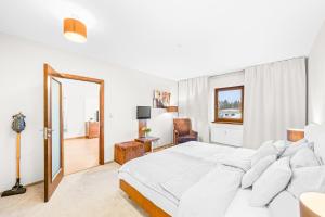 a white bedroom with a large bed and a mirror at Prostorný dvoupokojový apartmán 52m2 in Plzeň