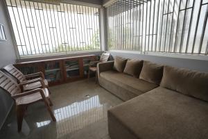 a living room with a couch and chairs and windows at Bhavasangama in Chikmagalūr