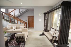 a living room with a couch and a staircase at Bhavasangama in Chikmagalūr +23 photos