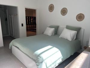 a bedroom with a large bed with green sheets and pillows at Markt 5 in Lier