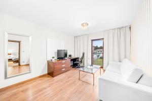 a living room with a white couch and a tv at Prostorný dvoupokojový apartmán 52m2 in Plzeň