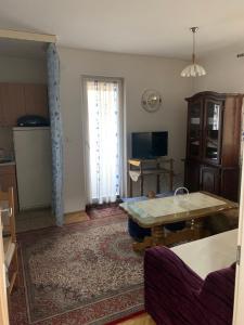 sala de estar con mesa y TV en D-apartmani, en Bijeljina