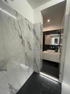 ein Bad mit einer Dusche, einem Waschbecken und einem Spiegel in der Unterkunft Casa Malupa Luxury Apartments in Rom