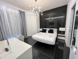 a black and white bedroom with a bed and a chandelier at Casa Malupa Luxury Apartments in Rome