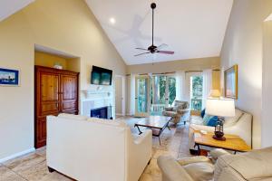 uma sala de estar com mobiliário branco e uma ventoinha de tecto em Eagle Watch em Hilton Head Island