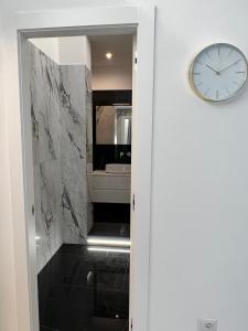 a clock on a wall next to a bathroom at Casa Malupa Luxury Apartments in Rome