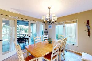 uma sala de jantar com uma mesa de madeira e cadeiras em Eagle Watch em Hilton Head Island