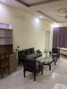 a living room with couches and a glass table at Trikuta Homestay in Jammu