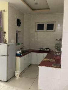 a kitchen with white cabinets and a counter top at Trikuta Homestay in Jammu