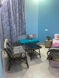 a room with a couch and a table and chairs at Trikuta Homestay in Jammu