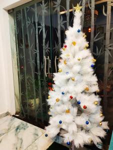 un arbre de Noël blanc devant une porte dans l'établissement DE LUMA Beach View, à Pondichéry