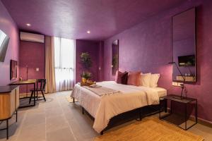 1 dormitorio con paredes moradas y 1 cama grande en Colorful & Lively Centro Gem 5BR, Rooftop Patio en San Miguel de Allende
