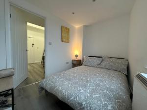 um quarto com uma cama e um candeeiro sobre uma mesa em Newly refurbished Studio flat Colwyn Bay em Colwyn Bay