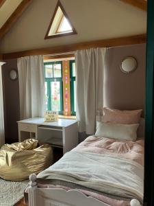 een slaapkamer met een bed, een bureau en een raam bij Landhaus Ana-Vital in Merzig