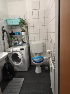 uma pequena casa de banho com uma máquina de lavar roupa e um WC em Leineblick em Seelze