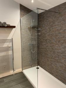 a glass shower in a bathroom with a brick wall at Millbrae Lodges in Belfast