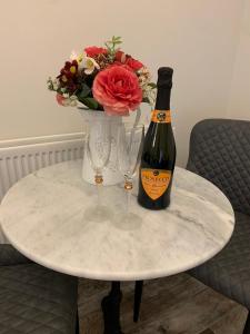 een tafel met een fles champagne en twee wijnglazen bij Millbrae Lodges in Belfast