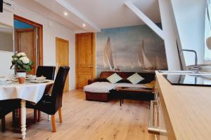 a living room with a table and a couch with sails on the wall at *Villa Marine*La Vigie - Duplex in Coudekerque-Branche