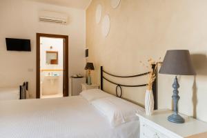 um quarto com uma cama com um candeeiro e uma casa de banho em Palazzo De Luca by Apulia Hospitality em Fasano