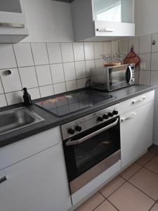 uma cozinha com um fogão e um micro-ondas em Leineblick em Seelze