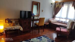 sala de estar con TV, sofá y mesa en Villa Dalam laut 530 en Pantai Cenang