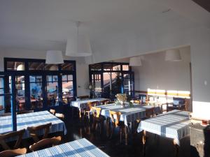 a restaurant with tables and chairs with blue and white tablecloths at Gorgona Hotel in Skála Sykaminéas