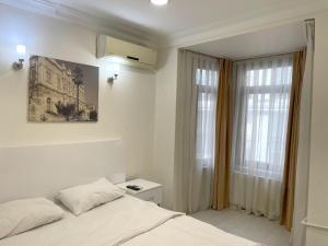 a white bedroom with a bed and a window at Eagle Residence Taksim in Istanbul