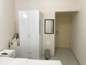 a white bedroom with a white cabinet and a door at Eagle Residence Taksim in Istanbul