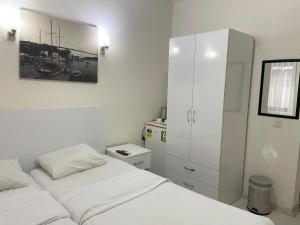 a white bedroom with two beds and a cabinet at Eagle Residence Taksim in Istanbul