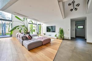 ein Wohnzimmer mit Sofa und Fernseher in der Unterkunft L'Eve - Maison pour 12 personnes - Ping-Pong in Le Perreux-sur-Marne