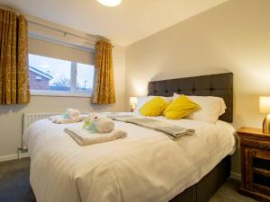 een slaapkamer met een groot wit bed en handdoeken bij Pass the Keys Fantastic Coastal House in Tynemouth