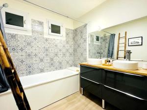 ein Badezimmer mit zwei Waschbecken, einer Badewanne und einem Badetubermott in der Unterkunft LOASIS - Appart T4 proche Gare et Centre Ville in Villefranche-sur-Saône