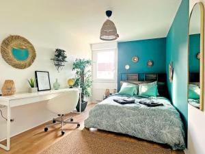 Schlafzimmer mit blauen Wänden, einem Bett und einem Schreibtisch in der Unterkunft LOASIS - Appart T4 proche Gare et Centre Ville in Villefranche-sur-Saône
