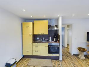 a kitchen with yellow cabinets and a sink at Alsdorf 3 in Alsdorf +7 photos