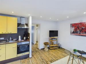 a kitchen with yellow cabinets and a dining room at Alsdorf 3 in Alsdorf
