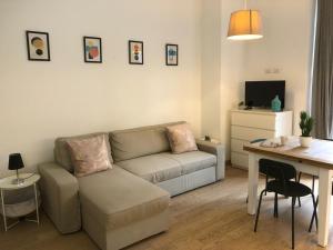 un soggiorno con divano e tavolo di ORTI COURT HOME a Milano