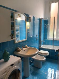 bagno blu con lavandino e lavatrice di ORTI COURT HOME a Milano