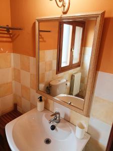 W łazience znajduje się umywalka i lustro. w obiekcie Casa rural de la Abuela w mieście Cadreita