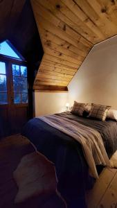 a bedroom with a large bed with a wooden ceiling at Luna Roja Llao Llao in San Carlos de Bariloche