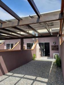 a wooden pergola on the side of a building at Casa do Nei in Bombinhas