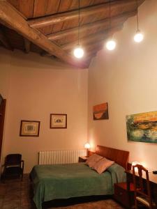 1 dormitorio con cama, mesa y luces en Casa rural de la Abuela en Cadreita