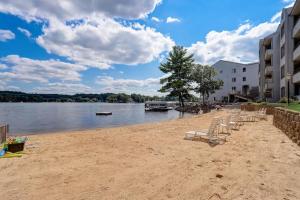 a beach with lounge chairs and a body of water at Dells Lakefront Escape - Couples or Families in Wisconsin Dells