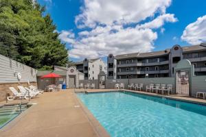a swimming pool with chairs and a building at Dells Lakefront Escape - Couples or Families in Wisconsin Dells